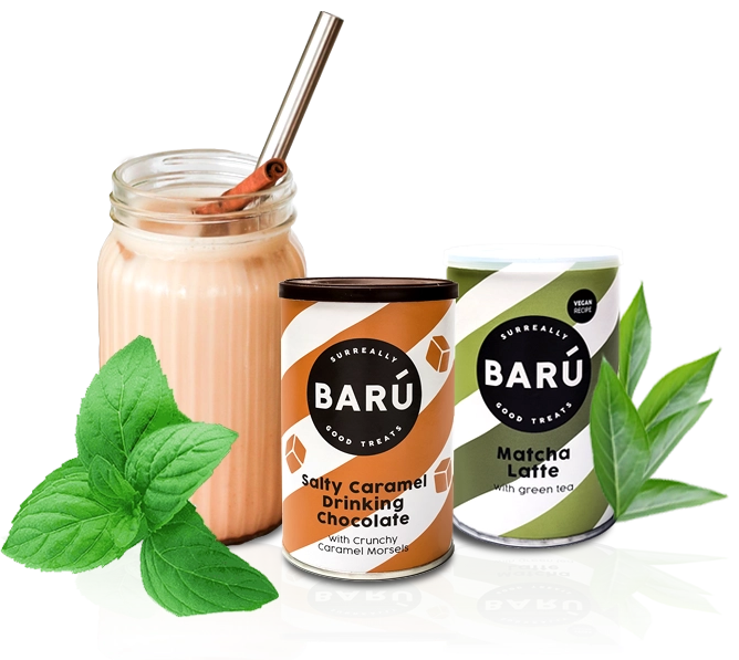 Two BARÚ brand canisters—Salty Caramel Drinking Chocolate and Matcha Latte with green tea—set against a black background with a fresh mint garnish and a tall, creamy latte in a glass jar with a metal straw.