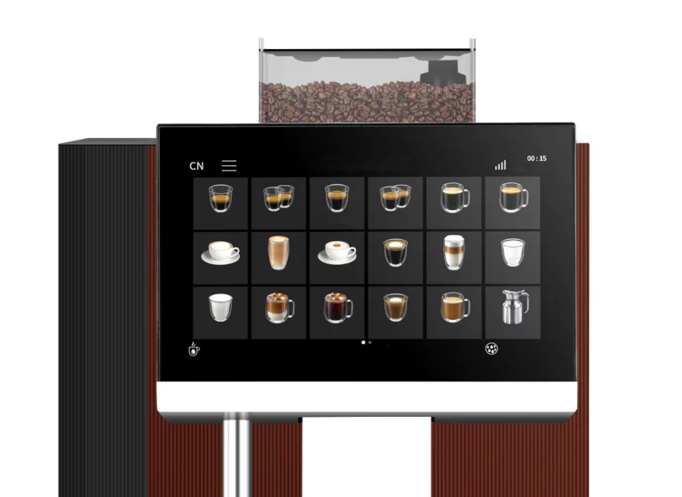 A close-up horizontal shot of the control panel of a professional coffee machine against a white background. A large black touchscreen displays a grid of eighteen different beverage options, including espresso, lattes, and cappuccinos.