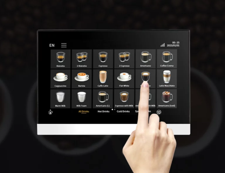 A hand selecting a "Macchiato" from a digital F16 touch screen menu. The screen shows icons for Ristretto, Espresso, Cappuccino, and more.