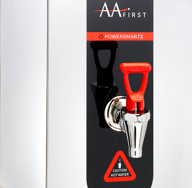 A close-up shot of the AA First PowerSmart 3 hot water boiler, featuring a stainless steel body, a black control panel with a red "Caution Hot Water" sign, and a distinctive red dispensing tap.